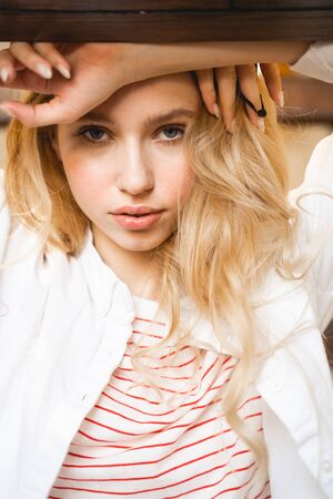 Serious blonde leaning on her arms while posing on cameraの写真素材