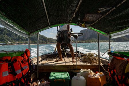 Strong man driving a boat, going to visit new islandの写真素材