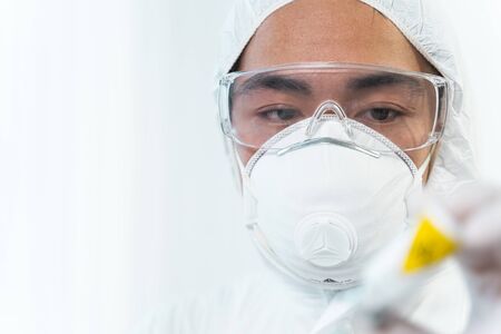 Time to work. Attentive international researcher having mask on face while testing new vaccine