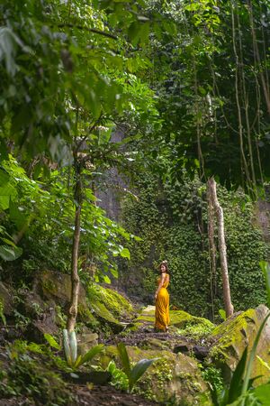 Follow me. Cute brunette standing in semi position and enjoying beautiful wild landscape stock photoの写真素材