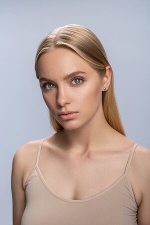 Beautiful modern young blonde Caucasian female with a sad expression looking in front of herの写真素材