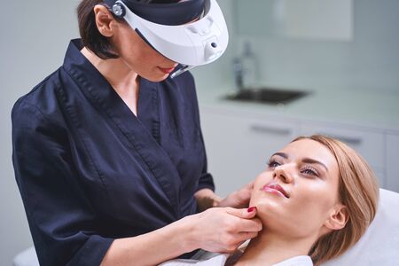 Well done. Pretty blonde girl visiting beauty salon while going to do mesotherapyの写真素材