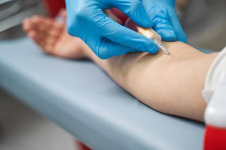 Medical care. Focused photo on female hand that being in protective gloves while doing prick