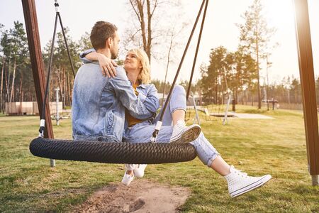 Love and tenderness. Smiling loving attractive young Caucasian lady gazing fondly at her short-haired boyfriendの写真素材