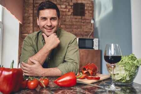 Portrait of a smiling contented middle-aged amateur cook posing for the camera in the kitchenの写真素材