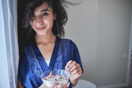 Beautiful young international woman looking forward while having lazy morning during self-isolationの写真素材