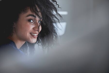 Charming international female person expressing positivity while spending her morning at home