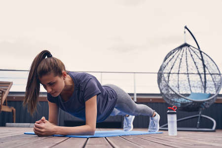 Attractive fitness lady in sportswear working out at rooftop loungeの写真素材