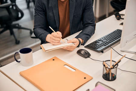 Project manager using computer and working on new project at his desk in the officeの写真素材