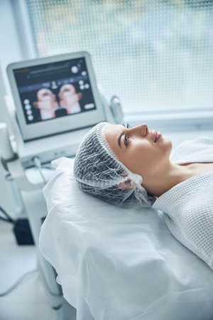 Female client lying on couch and looking up in expectation of lifting procedure