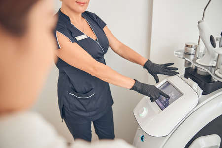 Doctor explaining her procedure of treatment on device while demonstrating figures on the screenの写真素材