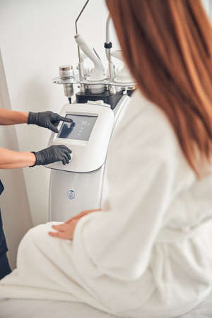 Close up photo of two persons while one of them pressing the screen of special applianceの写真素材