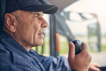 Close up photo of adult successful firefighter talking on the walkie talkieの写真素材