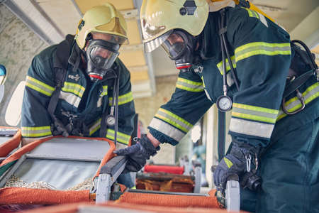 Portrait of two firefighters demonstration their knowledge of fire safety in the plane salon