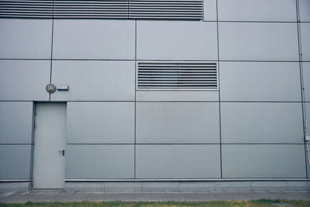 Close up of storage or warehouse building with gray entrance door