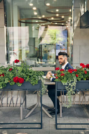 Handsome brunette male person being in cafe while having business lunch after conferenceの写真素材