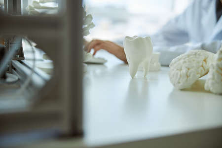 Cropped photo of a man in a lab coat sitting at a desk in a research laboratoryの写真素材
