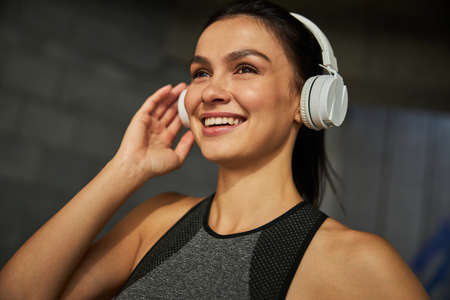 Amazing brunette sportswoman keeping smile on her face while thinking about run resultの写真素材