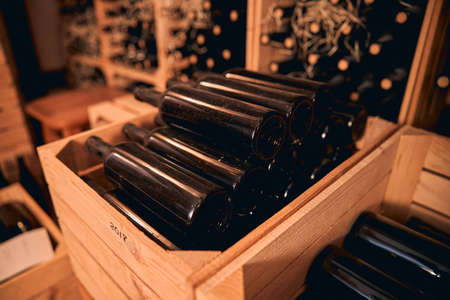 Glass bottles of alcoholic drink in wooden crate with vintage year label