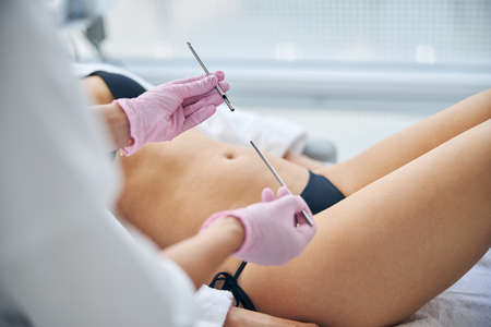 Cropped photo of a female patient lying during a medical procedure in a beauty parlorの写真素材