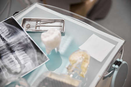 Top view of medical table set up with dental tools, props and dental radiogram