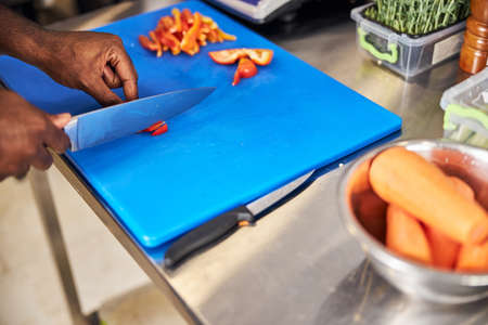 Top view close up cropped head of chef using knife for cooking and preparing stuffing of tomatoes...
