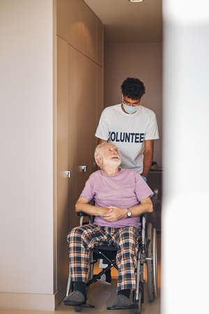 Front view of a senior Caucasian man in the wheelchair looking up at his carerの写真素材