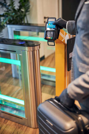 Cropped photo of a business official swiping his bank card over an electronic scanning device at the...