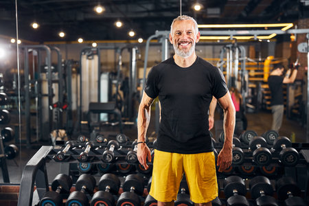 Front view of a handsome cheerful Caucasian bodybuilder in casual clothes posing for the cameraの写真素材