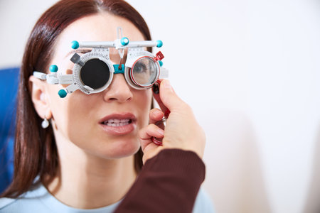 Adult rotating the lens in a test frame on a female face for regulating the resolutionの写真素材