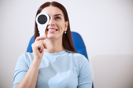 Waist-up photo of a woman putting an eye cover and checking the vision of her left eye