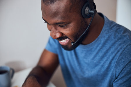 Close-up photo of an enthusiastic worker pleased about his online discussion with co-workersの写真素材