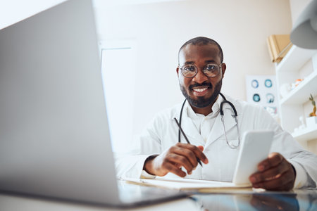 Medical worker with stethoscope sitting in his smartphone while looking for additional information for diagnosisの写真素材