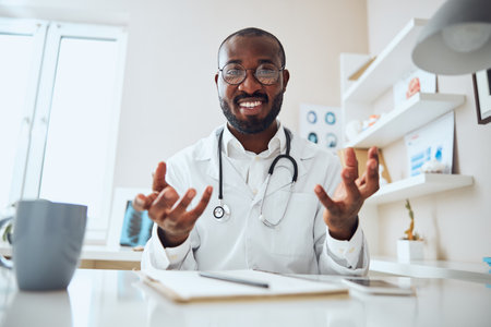 Specialist making gestures with his arms while talking happily about his patient medical conditionの写真素材