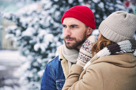 Caring man and woman are spending good time together in nature on cold winter dayの写真素材