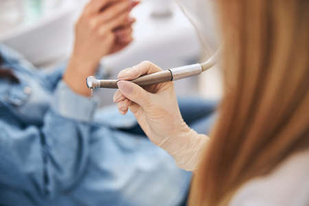 Concentrated stomatologist sitting near patient while consulting about teeth careの写真素材