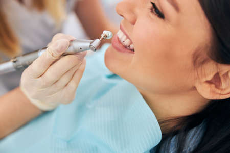 Young female person keeping smile on her face while being satisfied with the result
