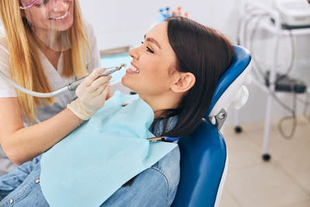 Young happy female being in all ears while listening to her stomatologist