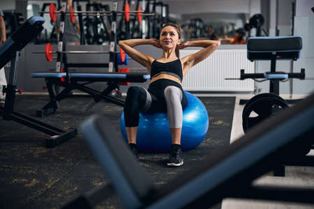 Pleased sportswoman having active training in the gymの写真素材