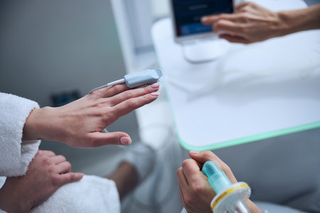 Patient having her oxygen saturation level measured by a pulmonologistの写真素材