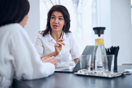 Experienced general practitioner consulting her female patient