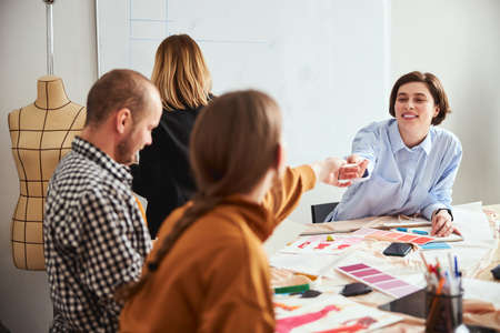 Positive designer sharing notes with her colleaguesの写真素材