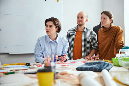 Team of young designers expressing surprise and interest