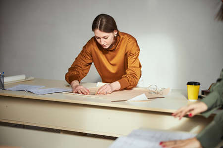 Dress designer drawing a circle on paper sheet