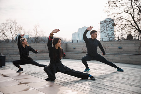 Three people doing tai chi deep side lungeの写真素材