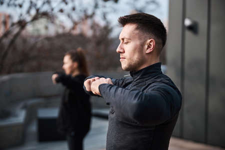 Handsome male joining fists while having tai chi trainingの写真素材