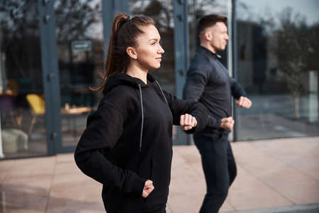 Self-assured female enjoying tai chi workout with her partnerの写真素材