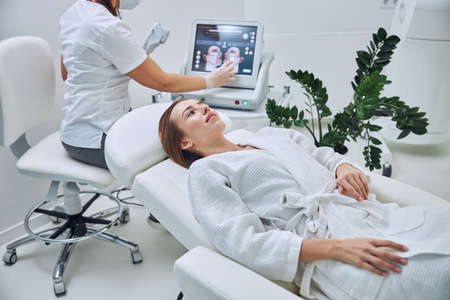 Pretty young Caucasian female waiting spa treatment procedure in beauty clinicの写真素材