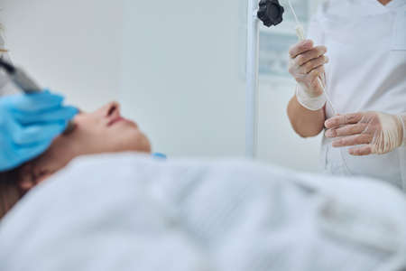 Focused image of physician arms during medical procedure in beauty clinic
