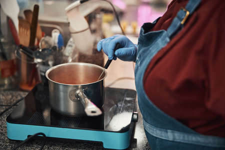 Busy chef in gloves preparing ingredients for the mealの写真素材